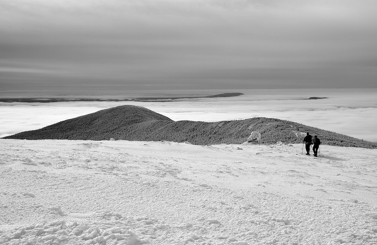 hiker in a sea of clouds on Mt. Moosilauke, White Mountain National Forest, New Hampshire