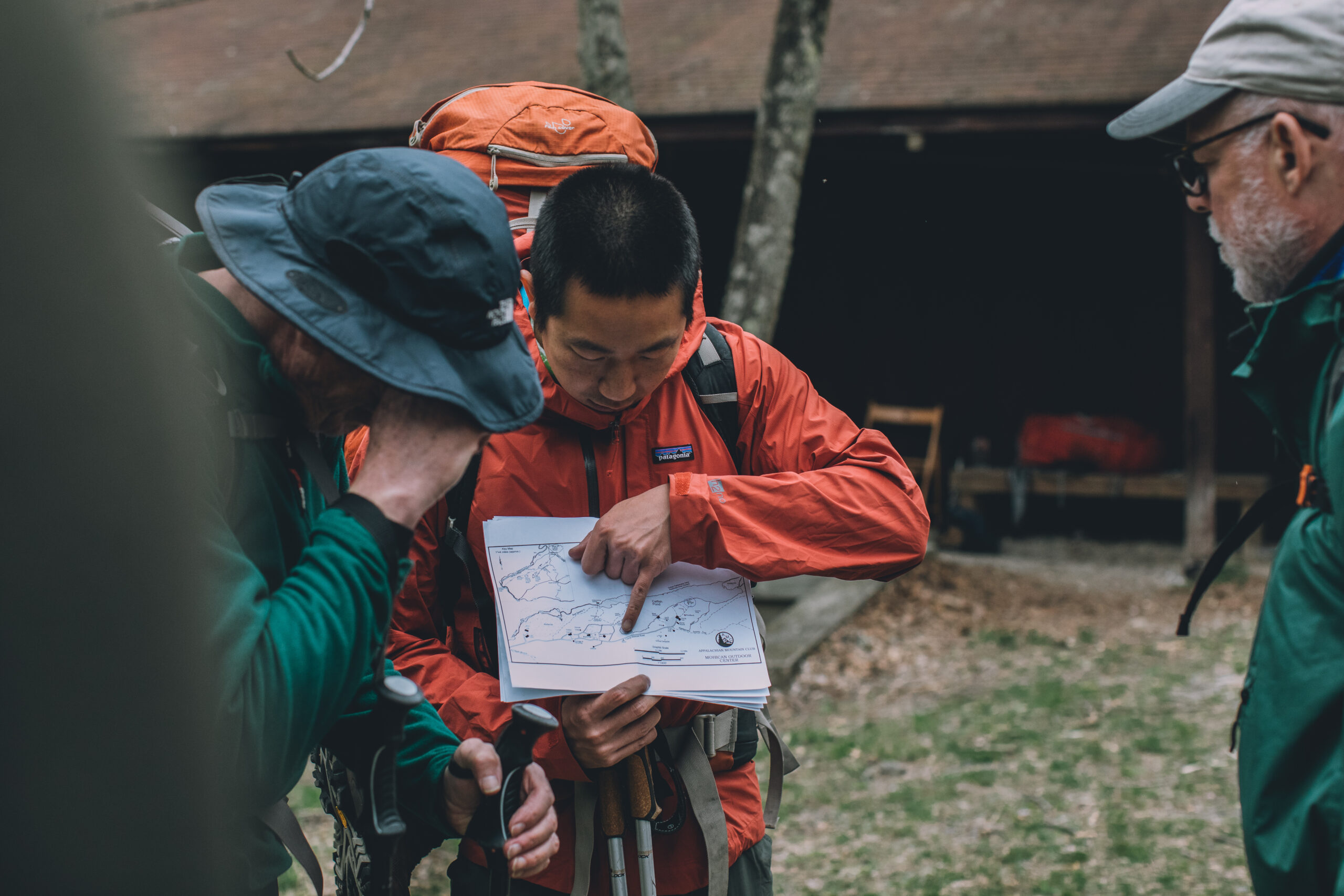 Person pointing to map and giving directions to fellow hikers.